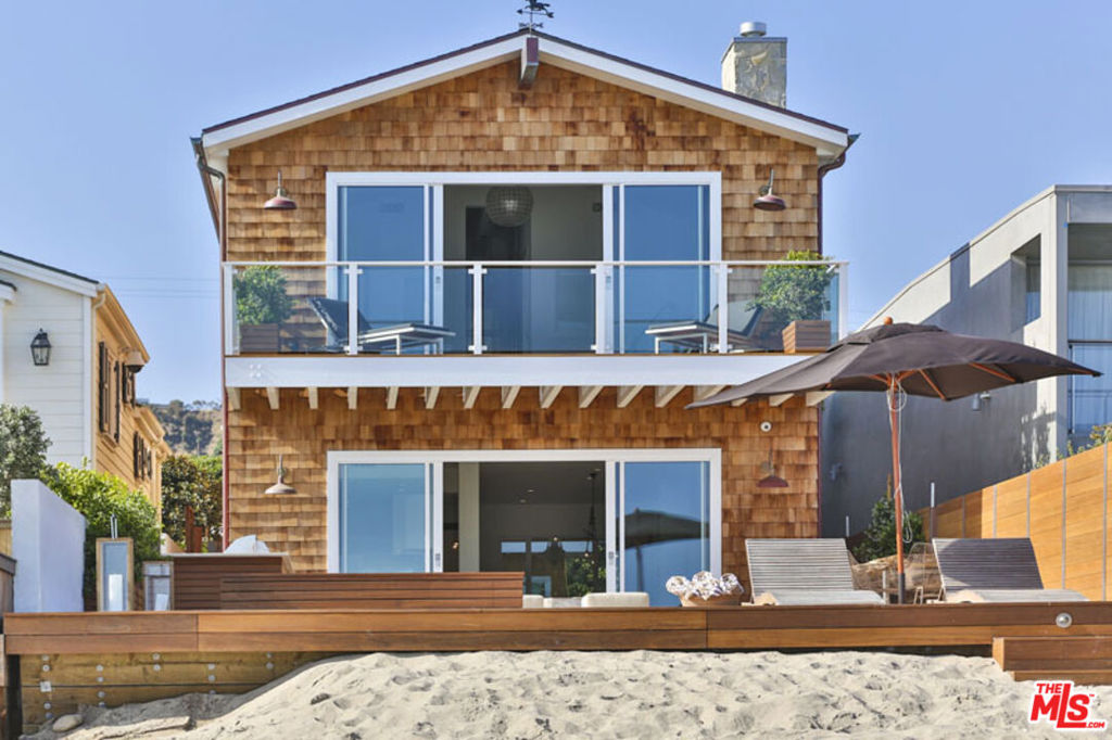 Stunning Cape Cod-style home set on Malibu Road with unobstructed views and direct access to a deep and sandy beach. This sought-after enclave is renowned for its exclusivity and pristine beachfront. This 6BD, 8BA home seamlessly blends traditional charm with contemporary elegance. It was crafted with meticulous attention to detail and boasts an expansive open floorplan. Natural light fills the home and highlights the high-end finishes throughout including dark oak flooring, travertine accents, and Carrara marble countertops. The living room offers a fireplace, ocean views, and floor-to-ceiling Fleetwood sliding doors that open to a spacious deck for indoor/outdoor living. The deck is perfect for entertaining with multiple seating areas, a firepit, built-in BBQ, spa, and has steps down to the beach. The kitchen is equipped with top-of-the-line amenities including Wolf Range and Sub-Zero fridge. The second floor offers a spacious primary suite with fireplace and private deck that overlooks the Pacific Ocean. There is a separate guest studio/suite on site that is perfect for family and friends. The garage has an electric car charger. With direct beach access, panoramic ocean views, and top-of-the-line amenities, this home is the epitome of luxury living in Malibu.