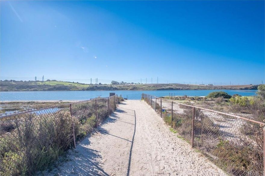 Step into this stunning, fully remodeled home in the exclusive, gated enclave of Laguna Shores-just 26 residences nestled in a private cul-de-sac.  This home is bathed in natural light and showcases serene views of the Agua Hedionda Lagoon and Carlsbad hills. Renovated by San Diego design-build firm Rice Interiors, you'll find a thoughtfully reimagined interior featuring an open, airy layout with dramatic volume ceilings, skylights and transom windows. The brand new kitchen, with two-tone white and oak cabinets, zellige tile, large island, custom range hood and all new LG appliances, is a showstopper- all three bathrooms have been beautifully redesigned with modern vanities, Delta plumbing and natural tile. Luxury flooring throughout complemented by upgraded Milgard windows and doors. This versatile floor plan includes a spacious bedroom and bath on main level while upstairs boasts dual primary suites with spa-inspired bathrooms. This is a rare opportunity to own a fully remodeled home and enjoy all the many amenities that this wonderful coastal community has to offer!