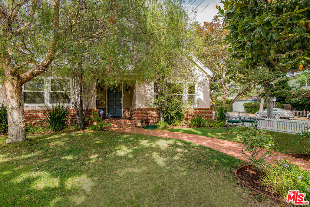 Welcome to this stunning traditional home, perfectly situated on a charming corner lot. Just a block away from the highly sought-after Westwood Charter School, this residence boasts a blend of modern updates and warm, inviting finishes. Step inside to discover wide plank hardwood floors that flow seamlessly throughout the home. At the heart of the home is a modern kitchen designed for both everyday living and entertaining, featuring high-end appliances, generous storage, and an open layout that connects to the living and dining areas as well as the backyard. The backyard is an entertainer's dream, complete with a built-in grill, dining area, and fireplace. The primary suite is a true retreat with a completely renovated, spa-like bathroom, while the second bathroom has been stylishly updated with contemporary finishes. In addition to the three spacious bedrooms, there's a versatile bonus room that can serve as an office or a cozy TV room. This home is a perfect blend of elegance and comfort, ready to welcome you.