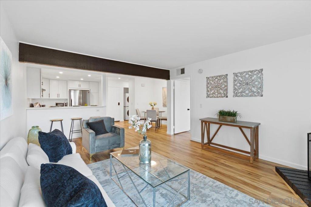 Tucked within the serene Woodlands community of San Carlos, this freshly painted residence has been thoughtfully remodeled to blend comfort and style. Luxury vinyl plank flooring guides you through an inviting layout, highlighted by a newly upgraded kitchen featuring stainless steel appliances, abundant cabinetry, sleek countertops, modern hardware and recessed LED lighting. The kitchen seamlessly connects to a spacious living room, anchored by a warm fireplace and opening through newer dual-paned sliders to a tranquil, south-facing patio with peaceful, park-like views—perfect for morning coffee or evening unwinding. The generous bedroom offers dual closets and a large newer window, while the en-suite bath boasts an updated vanity, new counters, a fresh tub/shower and recessed lighting. A stylish half bath for guests enhances both privacy and convenience. Additional upgrades include a newer in-unit washer and dryer, new A/C and heater with Bluetooth-enabled thermostat, an updated electrical panel, a private garage with keypad entry and built-in storage plus extra parking pass and a newer water heater. Residents of The Woodlands enjoy an array of resort-style amenities including two pools, two spas, tennis courts, a clubhouse, elevator and winding park-like paths with fountains. Ideally located, this walkable neighborhood places you just steps from a grocery store, pharmacy, hardware shop, coffee house, dining, and the San Carlos Branch Library, with Cowles Mountain Trailhead, Lake Murray, and Mission Trails Golf Course only minutes away. Experience turnkey living in one of San Diego's most sought-after communities!