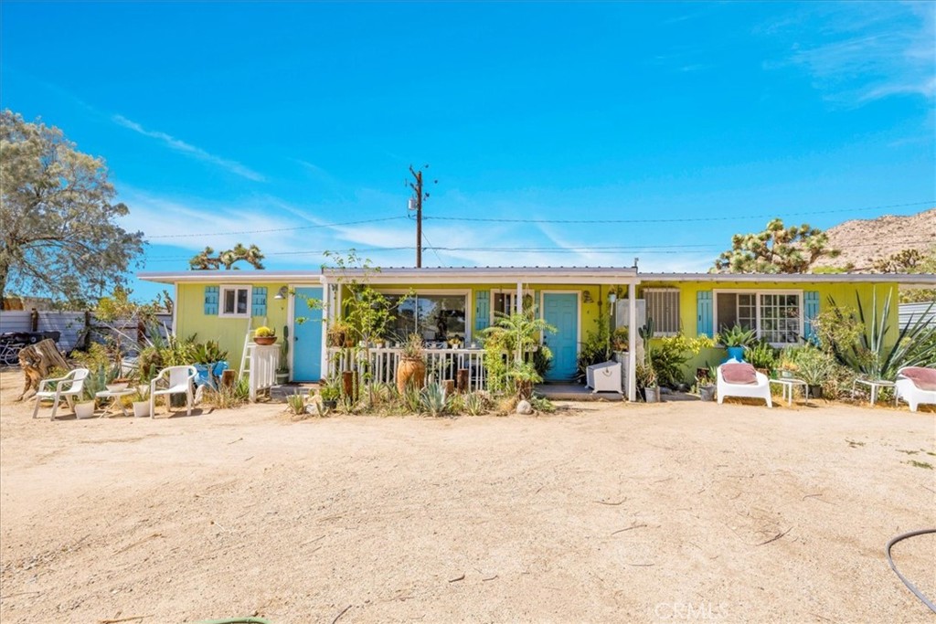 This charming 2 bedroom, 1 bath home on 1/3 acre in north downtown Yucca Valley combines comfort, style, and privacy with a convenient location. Beautiful landscaping and mountain views welcome you, along with a secure outdoor parking area and privacy fencing in both the front and backyard. Covered patios at the front and back of the home provide inviting spaces to relax outdoors in your own private oasis. Inside, the living room is spacious with high beamed ceilings, tile flooring throughout, and new windows that fill the space with light. The kitchen is nicely appointed and features an informal dining area with sliding glass doors to the backyard, plus a separate formal dining room for added flexibility. The bathroom is generously sized and includes a tub/shower combo. The first bedroom offers built-in storage and plenty of space, while the second bedroom is oversized with abundant natural light and large closet. A sizable bonus room provides even more versatility for work, hobbies, or guest use. Furniture is included, making this property move-in ready. With its thoughtful updates, spacious design, and excellent outdoor living features, this home is a wonderful opportunity in a desirable Yucca Valley neighborhood.