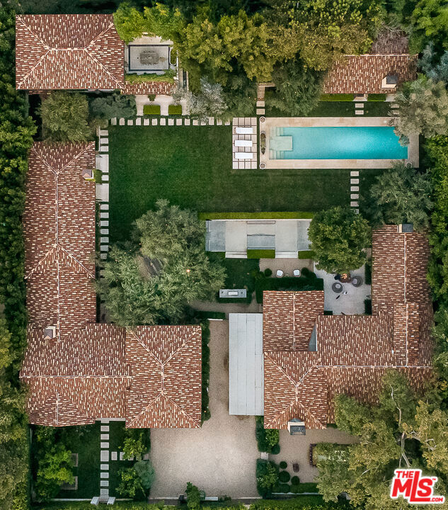 Concealed behind lush green ficus hedges, an unparalleled urban hideaway awaits. Be transported by the sounds of tranquil fountains and rustling trees into a consciously designed compound occupying 26,499 sq ft in the heart of West Hollywood. The residence is an experiential property comprised of 4 structures - each offering a cohesive yet custom live/work experience. Connected by a casually chic courtyard and salt-water pool, the grounds are brimming with vintage flair and finesse. The first structure contains two airy sitting rooms, separated by a wood-beamed kitchen outfitted with a stunning La Cornue range. You'll also find a spacious primary suite and inviting guest-rooms. The second structure features a vast open concept kitchen with three additional suites; one notably opening to the courtyard. Take a winding stairwell down to the intimate bar and Moroccan inspired theater. A stylish open format casita stands as the third structure and leads to the fourth building which is complete with a private terrace overlooking the expansive grounds. An indoor/outdoor office makes for an inspiring work area and can be easily-converted into living space upstairs, while a stylishly retrofitted game deck and gym account for the main floor. Intuitive designer, Morgan Brown developed the estate as an intentional retreat, peppering whimsical moments throughout the grounds from a cozy fire-pit to a secluded hot tub, tree-veiled gazebo, and a backyard skate ramp. Built with all of the resort essentials the compound inspires restoration and ideation as an all-inclusive, constructive gathering space. This multifaceted property pairs function with style and comfort to serve as the ultimate private homestead just blocks from Soho House and West Hollywood's most acclaimed shopping, dining and social districts.