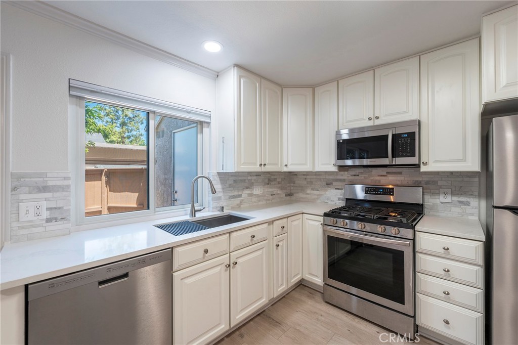 Completely remodeled 2 Bedroom and 1.5 Bath Townhouse located close to the neighborhood park and swimming pool. Walk in to a spacious living room with a fireplace. Brand new laminate flooring in all the rooms. The kitchen has been remodeled with quartz countertop, designer backsplash, upgraded cabinets, gas cooking range, deep kitchen sink and stainless steel appliances. Brand new washer and dryer located downstairs. Kitchen opens up to a cozy backyard which has a beautiful peach tree. Upgraded dual pane windows throughout the house and brand new sliding door makes the house energy efficient. Upstairs both bedrooms have laminate flooring. The bathroom has been completely remodeled as well. Large walk in closet in the master bedroom. Brand new AC. All appliances included! Two assigned carports right next to the backyard makes it easily accessible. There is ample parking available on the street. Residents of this fantastic Woodbridge community have access to an array of resort-style amenities, including two lakes with sand beach lagoons, boating and fishing facilities, 20 pools, over 20 tennis courts, playgrounds, parks, a splash pad, a fitness course, and numerous family-friendly activities.