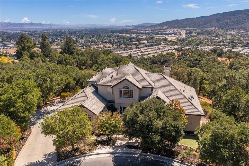 Nestled in The Forest, Gilroy's most exclusive gated community, this stunning custom estate embodies tranquility, luxury and extreme privacy. Located at the end of a serene court, enveloped by vast open space. With an amazing open floor plan and tons of natural light pouring through numerous windows, every room offers breathtaking, unobstructed views that captivate from dawn to dusk. The main floor features the primary bedroom retreat, complete with a newly remodeled luxurious bathroom, spacious closet, and custom built-in cabinetry. The gourmet kitchen is a chef's dream, boasting sleek quartz countertops, a convenient walk-in pantry, and a high-end Viking gas range. Downstairs also includes a versatile office with French doors, while upstairs you'll find three additional bedrooms and two bathrooms for family or guests. Step outside to the entertainer's paradise backyard, highlighted by a large pool, brand-new deck, a commercial pizza oven, raised garden beds, open grass space - all set against a backdrop of tranquil beauty in this prestigious enclave.