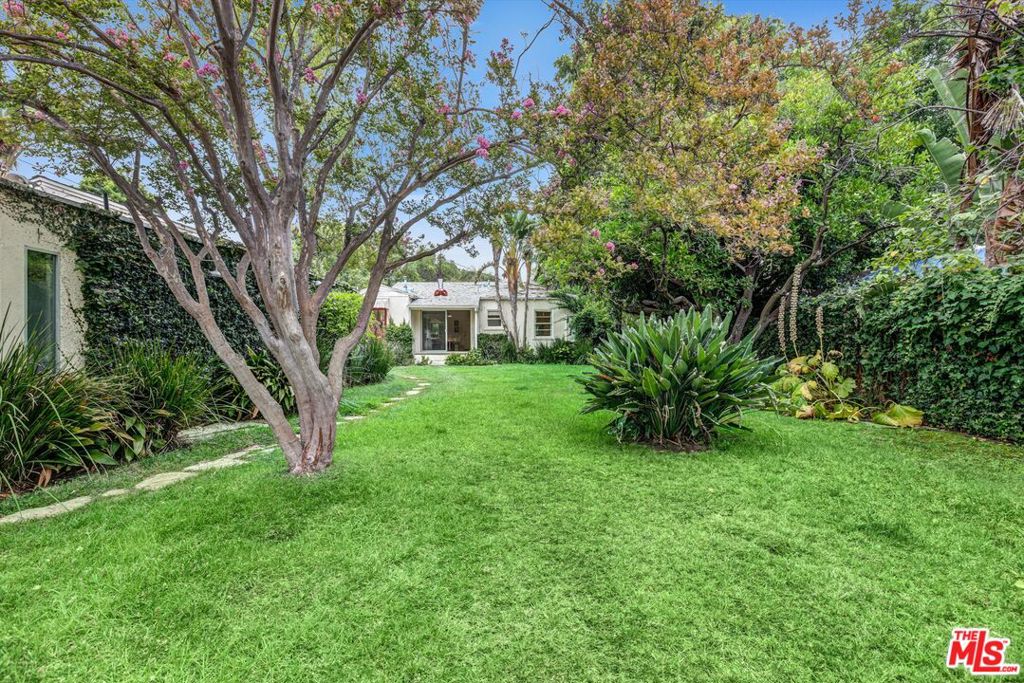 Enchanting and classic gated bungalow, circa 1941, set on a rare expansive lot that captures the spirit of Southern California living. Bathed in natural light, the spacious living and dining areas open seamlessly to the outdoors. A vintage-inspired kitchen feels both functional and true to the home's character. The primary bedroom offers a serene retreat, while the second bedroom doubles as a library or office. Outside, lush landscaping frames a private sanctuary designed for relaxation and entertaining. Enjoy the hot tub and sauna, or unwind in a hammock beneath the greenery. A European-style guest house with kitchenette and bath enhances the property's versatility, ideal as a writer's retreat, creative studio, or guest accommodations. Secluded on a quiet street with no through traffic, the home offers rare peace and privacy with convenient access to the city. A unique furnished lease opportunity, it combines timeless character with lifestyle amenities seldom found at this scale. Main house is 2 bedroom 1 bath. Guest house is 1 bedroom 1 bath.