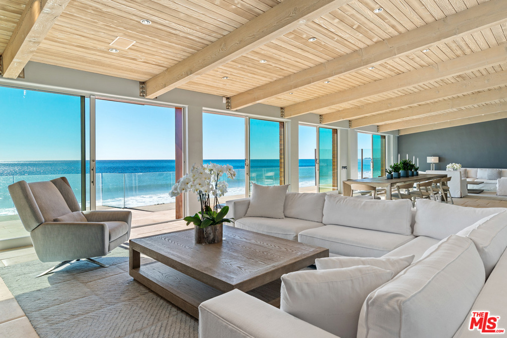Gracious and stylish contemporary with 60' of beach frontage and non-stop coastline, ocean, and island views. High, wood-plank ceilings, skylights, stone tile floors, expansive glass doors facing the ocean for an atmosphere of luminous tranquility. Oceanfront living/dining great room with fireplace, built-ins, wet bar seating area, multiple glass doors onto a full-width deck for dining and relaxation. Sensational gourmet kitchen with island seating, granite countertops, quality appliances, beautiful wood cabinets. Three en-suite bedrooms on main level. Upstairs is magnificent owners retreat, expansive and tranquil, with spacious sitting area, generous built-ins and closet space, lavish bath, and large covered balcony. Gated front courtyard offers additional gathering space and barbecue island. Detached garage, guest parking, smart home technology. A stunning contemporary residence in an ultra-desirable location, with easy access to restaurants, shops, and downtown Malibu.