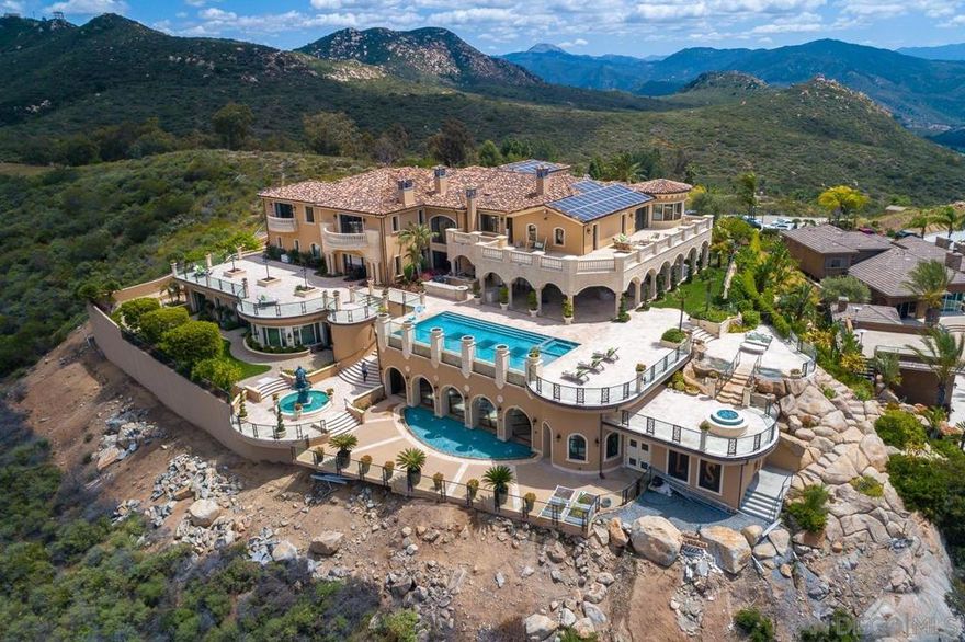 Unobstructed views from this palatial mountaintop estate! Custom built & meticulously handcrafted 13,631 sqft, 5 bed, 8.5 bath retreat designed by renowned architect John Jensen AIA and built by Tony Mezain AME Proline Inc features an attention to detail that is unparalleled. Enter the intricate double doors to soaring ceilings, expansive picture windows, elaborate woodwork, stone floors & a living space that offers a seamless transition between true indoor & outdoor living. Gourmet kitchen is every chefs dream with opulent cabinetry/fixtures & Wolf appliances. Sprawling beautifully tiled covered patio leads to sparkling vanishing edge infinity pool & numerous other entertaining spaces with water features and lush landscaping!  Swiss glass chandeliers in entryway, living room & east side stairs, over $1M in stonework completed by Alto Design from Las Vegas, custom designed and hand built iron work by H&M Iron, artist commissioned faux painting of the ceiling, Austrian veneer wood in the office & in the dome over the stairs, drapes hand made in Mexico, gold leaf & gold plated details, and all woodwork, millwork & carpentry was handcrafted in Michigan and transported to the site. No detail has been overlooked in the completion of this grand estate!