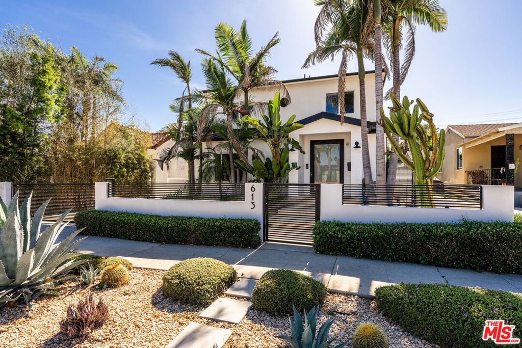 Welcome to this beautifully designed 4-bedroom, 4.5-bathroom contemporary residence in Beverly Grove, one of LA's most sought-after neighborhoods. Thoughtfully crafted with luxury, style, and comfort in mind, this bright and airy home showcases high ceilings, an open-concept layout, and a seamless indoor-outdoor flow. Step inside to discover an expansive great room-style living area that connects effortlessly to a chef's kitchen, complete with a generous center island with bar seating, ideal for both everyday living and entertaining. The open layout extends into a spacious family room and an inviting dining area, perfect for casual gatherings or hosting guests. The main level also includes a versatile ensuite bedroom that can double as a home office, along with a sophisticated formal powder room. Upstairs, three spacious ensuite bedrooms await, including a luxurious primary suite that offers the ultimate retreat: enjoy two walk-in closets and a spa-inspired bathroom with dual vanities, a soaking tub, glass-enclosed shower, and a private balcony overlooking the grounds. The backyard boasts a private pool, spa, built-in BBQ, and a generous patio with fireplace, ideal for al fresco dining and summer soirees. The converted garage adds valuable flexible living space, perfect as a pool house, game room, gym, or creative studio. With smart home features, gated entry, and a prime location just minutes from The Grove, LACMA, Melrose Avenue, and premier dining, shopping, and entertainment, this exceptional residence blends contemporary elegance with everyday ease.