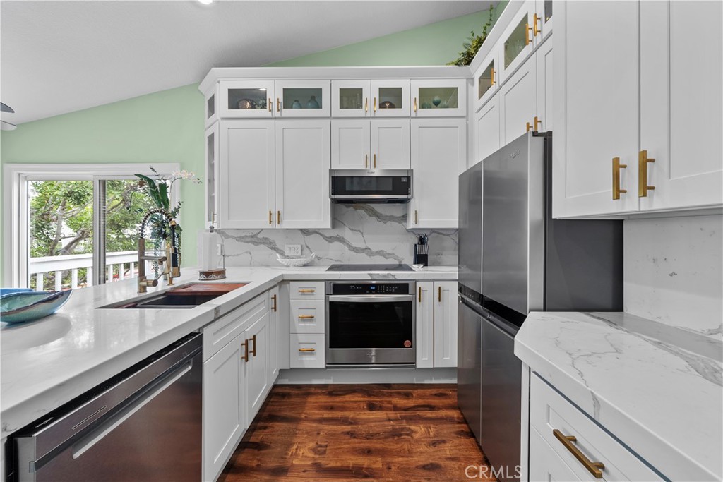 ***SHORT TERM/SEASONAL/VACATION or LONG TERM *** Welcome to “Seawatch” at Beacon Hill – A Coastal Gem! This beautifully upgraded, beach-close 2-bedroom, Fully Furnished end-unit condominium offers a perfect blend of style, comfort, and convenience in the heart of the highly desirable Beacon Hill community. Step into a bright and airy living space featuring vaulted ceilings, rich wood flooring throughout, fresh interior paint, and dual-pane vinyl windows and sliding doors. The open-concept floor plan is enhanced by an expansive private deck off the living room, ideal for enjoying morning coffee or evening sunsets surrounded by mature trees—creating a serene indoor/outdoor living experience. The fully remodeled kitchen is a showstopper, showcasing stunning porcelain countertops with a waterfall edge that seamlessly flows into the backsplash, offering a sleek and modern aesthetic. The kitchen is equipped with high-end stainless steel appliances, ample counter space for meal prep or entertaining, and custom extended-height cabinetry for maximum storage. The spacious primary bedroom includes sliding doors that open to the deck and a private en-suite vanity area that leads to a fully renovated bathroom featuring a custom-built vanity, quartz countertop, and a frameless glass shower with herringbone tile design. The second bedroom, located at the opposite end of the hallway, offers added privacy and is generously sized. Additional highlights include in-unit laundry with washer and dryer included, window blinds throughout, and stylish finishes in every corner. The home is being offered fully furnished, making it a perfect turnkey option for seasonal stays or short-term (30+ days) vacation rentals, or even a traditional yearly lease. The Seawatch community offers access to resort-style amenities including a sparkling pool, relaxing spa, tennis courts, and lush open green spaces. Located just minutes from world-renowned beaches, fine dining, premier shopping, top-rated schools, scenic coastal trails, and Laguna Beach’s charming trolley service — this is coastal Orange County living at its finest.