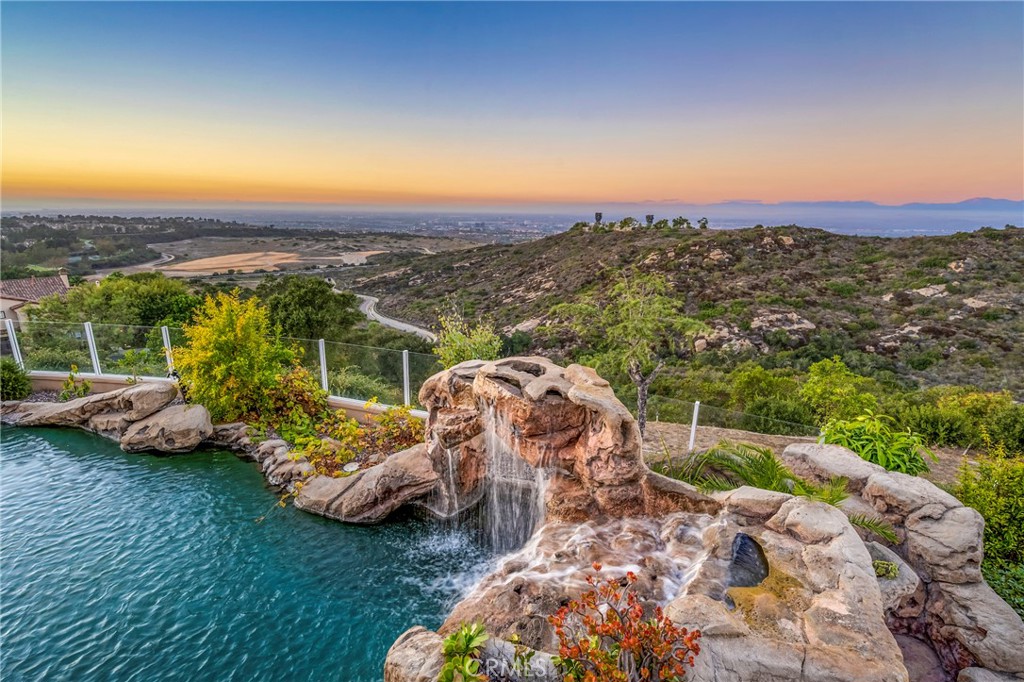Welcome to your dream home in the enchanting enclave of Newport Coast, CA! Nestled in the heart of luxury, this stunning 3-bedroom, 2.5-bathroom home is a haven of serenity and style. With 3,400 square feet, it's the perfect canvas for those who demand nothing but the best in coastal living. Step into a world of sophistication as you enter this exquisite residence. The expansive floor plan unfolds before you, with an abundance of natural light that flows seamlessly through the space. This home exudes a sense of grandeur while maintaining an inviting warmth that's perfect for hosting guests or enjoying quality family time. Let's talk about the heart of every home – the kitchen. And this one is a chef's paradise! The gourmet kitchen is equipped with top-of-the-line stainless steel appliances and granite countertops that offer both beauty and functionality. Adjacent to the kitchen, you'll find a spacious living room with a cozy fireplace, making it the ideal place to unwind and relax. But that's not all; the living room seamlessly leads to the outdoor oasis. The backyard boasts a charming rock pool with waterfalls and spa, the perfect setting for a weekend barbecue or a twilight swim under the stars. A beautiful Koi pond with fish is also included in the backyard. When it's time to retreat, the primary suite is the ultimate sanctuary. With a large outdoor deck, imagine waking up to the sun dancing on the water, as the ocean greets you every morning. The primary bathroom is your personal spa retreat with a soaking tub, dual vanities, and a walk-in shower – a luxurious escape within your own home. An additional two en-suite bedrooms offer plenty of space for family and guests, with each room thoughtfully designed for comfort and style. A den area with another outdoor deck adds versatility to the home, perfect for an additional family room, home office, or gym. The coveted community of Newport Coast is known for its exclusivity, security, and prestigious lifestyle. Whether you're looking for top-rated schools, upscale dining, or upscale shopping, you'll find it all within reach. Andiamo is just a short drive away from some of Orange County's finest attractions, including Crystal Cove State Park, Pelican Hill Golf Club, and the Newport Beach coastline. Don't miss your chance to experience this coastal dream.