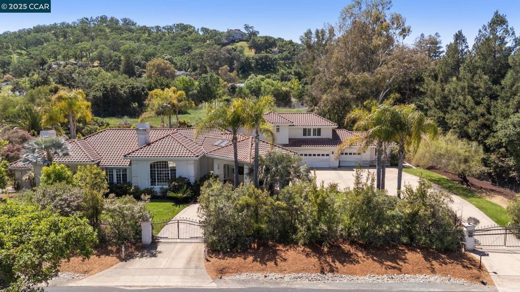Experience elevated California country living in this custom, private one-acre estate tucked along a bucolic lane near the Mt. Diablo foothills—just minutes from top-rated schools, upscale shopping, and dining. This spacious 4 BD, 3.5 BA residence offers generous living and entertaining spaces with soaring ceilings and views of serene gardens. Highlights include a luxurious downstairs primary suite with sitting area, chef’s kitchen with walk-in pantry, dedicated office, upstairs library/game room, multiple fireplaces, and a garage workshop. Outdoors, enjoy a sparkling pool, covered loggia, and lush Mediterranean gardens with mature palms, drought-tolerant blooms, citrus and fruit trees, and heritage walnuts. The flat lot offers excellent potential for an ADU, expansion, vineyard, or even horses. Listing agent is related to seller. Full virtual tour and more at: 195pinecreek.com/mls/184585851