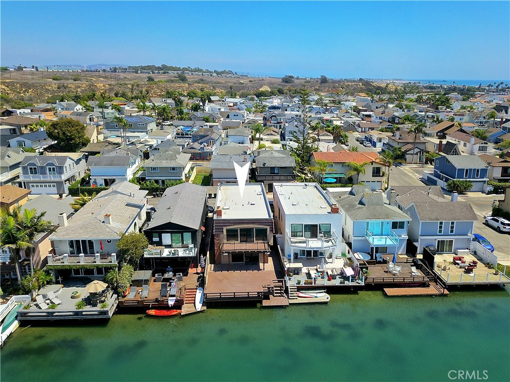 Great waterfront location just a few blocks from Newport Beach finest beaches and a view of the bird sanctuary. Large master bedroom with a deck for enjoying the view, a fireplace, built-ins, walk-in closet, crown molding, built-in ironing board and view of the canal and sunsets. Updated master bathroom with a walk-in shower, dual sinks, tub, a makeup area with granite counter tops and a skylight. Four more bedrooms with 2 bedrooms that have French doors. Newly painted in some rooms, newer carpet and newer fan lighting. 4th bedroom can be used as an office, also. Updated second bathroom with granite counter tops and tile floors. The downstairs powder room has a decorator cabinet, mirror and chandelier. All newer wood floors in the living room and dining room, newer carpet, paint, stainless steel stove, wine refrigerator, door hardware, recessed lighting and fan lighting throughout. Living room has a fireplace with built-ins and is open to the deck and canal. Oversized two car garage with built-ins and washer/dryer hookups, included. HOA amenities include the Newport Beach Community Association pool, tennis, clubhouse, play areas and Barbecue.