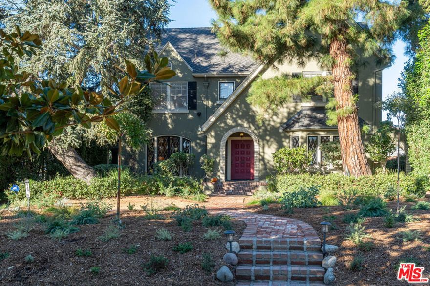 Character abounds in this lovely Windsor Square Country English with a classic center hall floor plan. The spacious living room boasts a fireplace and leaded windows. An adjacent cozy family room with French doors leads to a charming, covered patio. The formal dining room with leaded windows is accessed by pocket doors off the entry.  The bright and airy kitchen is equipped with newer appliances, a butler's pantry and an inviting breakfast nook. Also, downstairs there is 1 bedroom and 1.5 baths. Upstairs is a landing with built-in bookcases, 4 bedrooms and 2 updated baths. Hardwood floors throughout. Guest house above garage with kitchen and bath. Generous backyard with a pickle ball court and raised beds for your vegetable and herb garden. Plus, a drought tolerant front yard and EV charger.  Enjoy Robert Burns Park and Larchmont Village's farmers markets, cafes, shops and yoga studio just a few tree lined streets away.