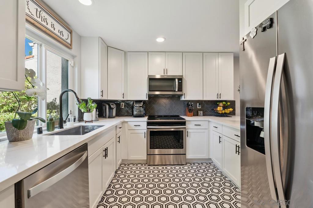 Welcome to this beautifully renovated 2-bedroom, 2-bath condo with a versatile loft-style den, ideally located in the heart of Poway. Remodeled in early 2020, this home offers modern design and thoughtful upgrades throughout. Soaring vaulted ceilings, exposed beams, and rich wood-style flooring anchor the open-concept living and dining areas, which feature updated ceiling fixtures and abundant natural light. The designer kitchen showcases crisp white cabinetry, black hardware, quartz countertops, stainless steel appliances, and bold geometric tile flooring. Both bedrooms include updated flooring, while the primary suite features a stunning bath with a walk-in shower, glass enclosure, and modern finishes. The upstairs loft provides flexible space for a home office, lounge, or guest area. Step outside to a private covered patio overlooking a lush greenbelt—ideal for relaxing or entertaining. Additional highlights include in-unit laundry, ample storage, and easy access to walking trails, dining, and award-winning Poway schools.