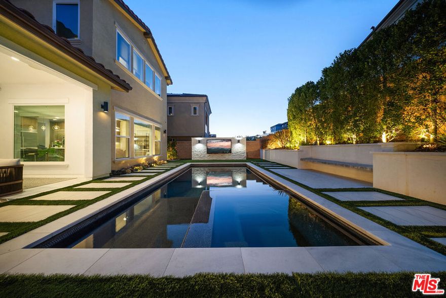 THE ONLY HOME available with a POOL in HILLCREST! Major Price Adjustment! Stunning New Construction in Hillcrest at Porter Ranch. Nestled within the prestigious, 24 HR guard-gated Hillcrest community, this exquisite 5-bedroom, 6-bathroom home offers 4,278 sq ft luxurious living space. This showcase modern design home offers high-end finishes throughout. Chef's kitchen featuring a custom Caesarstone oversized island, dual ovens, floor to ceiling cabinetry, elegant backsplash. Dramatic custom chandelier in foyer, beautiful pendant lighting over the island, and stunning light fixtures throughout. Spacious bonus family room enhancing the open-concept layout. Each bedroom includes its own en-suite bathroom for added privacy. The generous sized Primary suite features a private retreat, coffered ceilings, elegant custom paint, expansive walk-in closet, a custom oversized tub, and glass enclosed shower with floor to ceiling luxurious tile. Rich hardwood floors throughout, complementing the seamless indoor-outdoor flow. Exterior & Community Amenities include Expansive rear yard with a gorgeous inground pool/spa. Designer TV wall, Waterfall edge stone island with Built-in stainless steel BBQ.  Located within a short distance to highly coveted PRCS TK-8. Close proximity to premium shopping, hiking trails, fine dining, & vibrant entertainment options. This meticulously upgraded home epitomizes luxury living in Porter Ranch. Click on the VIRTUAL TOUR LINK for a full video. Seller says Bring us an OFFER!