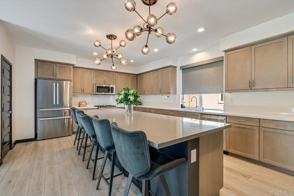 Discover modern luxury in this 2020-built townhome featuring 3 bedrooms, 4 bathrooms and 2,081 sq ft of thoughtfully designed living space. Perfectly positioned as an end unit overlooking the community park, this home enjoys one of the best locations within the neighborhood. The open-concept main level showcases a chef’s kitchen with quartz countertops, maple shaker cabinetry, stainless steel appliances, and a spacious island. The bright living and dining areas flow seamlessly to a private deck, creating the ideal indoor-outdoor lifestyle. Stylish finishes include designer light fixtures, luxury vinyl plank flooring, and an elegant open-rail staircase. A bedroom and bathroom on the first level provide comfort and flexibility for guests, family, or a home office. Upstairs, the serene primary suite features a spa-like en-suite bath, joined by a secondary suite with its own private bathroom, plus convenient upstairs laundry. Direct access to a 2-car garage adds everyday ease. Kensington at The Square offers resort-style amenities including a sparkling pool, bocce ball court, putting greens, parks and EV charging stations. All just steps from multiple stylish restaurants, coffee shops, and grocery stores—including Trader Joe’s—making it easy to enjoy the vibrant Bressi Ranch lifestyle.