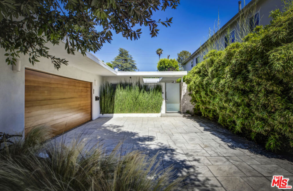 In the realm of shadowed splendor and architectural grace, behold a residence that whispers of a bygone age reborn a sanctuary of elegance where modernity meets refinement in seamless union. This abode, nestled in the heart of Studio City, has undergone a transformation most divine, sculpted with the meticulous hand of those who understand the language of beauty and form. A gate, like the threshold to some forgotten dream, beckons with an enigmatic allure, guiding one along a private path, a passageway that leads to the very soul of this dwelling. A dwelling, indeed, that shall not disappoint those who seek both solace and grandeur, for within its walls lies the perfect harmony of three bedrooms and two and a half baths, each a chamber of quiet opulence. The very breath of the home, the open floor plan, swirls with the elegance of a forgotten waltz living room to dining room, flowing effortlessly into a den of generous proportions, and beyond, to a chef's kitchen so lavish it could be the very domain of a culinary sorcerer. High-end JENN AIR appliances gleam like polished obsidian, while quartz countertops cool to the touch shine as if kissed by the very stars themselves. A mosaic backsplash whispers in secret tongues, and porcelain floors gleam with a brightness that rivals the moon on a cloudless night. The primary bath, an ethereal chamber of rejuvenation, lies just beyond the threshold of the master bedroom, offering an experience both transcendental and indulgent. Here, an oversized shower with its rain pouring down like a gentle storm invites respite, while a double floating vanity hovers as if in a dream. And lo, a separate jetted tub, a vessel of comfort and escape, awaits in serene repose. And yet, this tale is far from over. For beyond these walls of beauty, there exists a home that continues to unfurl its treasures. Engineered wood floors, as dark and deep as the midnight sky, stretch throughout the abode. An above-ground spa rests like a tranquil pool of stars in the night, while newer windows, crystalline and clear, invite only the purest light to enter. Lastly, a new garage door, as graceful as the wings of a raven in flight, completes the symphony of this magnificent dwelling. Indeed, within these walls, there is more than mere structure; there is the very essence of modern luxury, cloaked in the finest whispers of eternity.