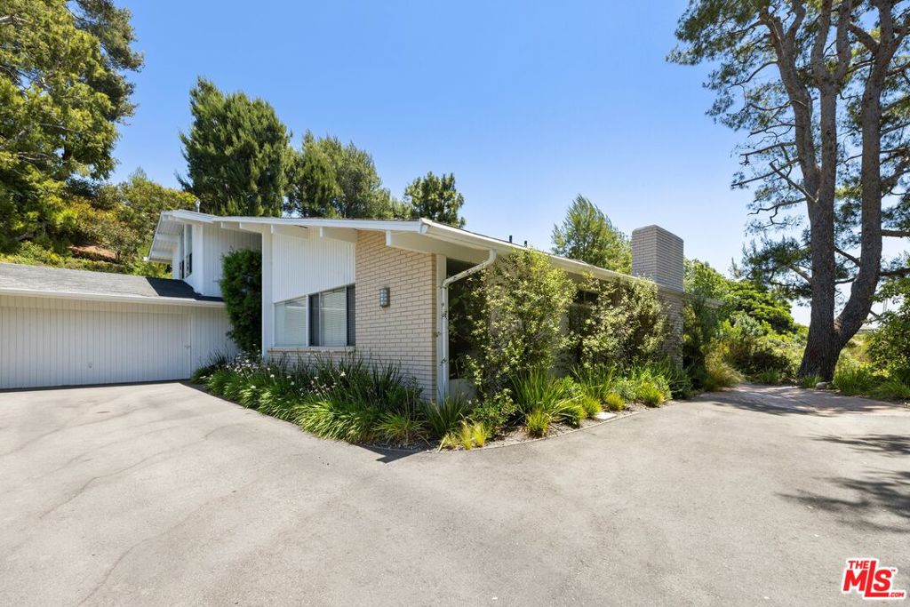 Private, secluded retreat off Westridge on a flag lot in magical Mandeville Canyon. 4 Bedrooms, 4 baths plus loft area, ideal for office or homework area. The interior has been just completely and professionally painted, including all cabinets. Wonderful living room with vaulted ceilings, fireplace, walls of glass and wood floors. Large separate family room with sliding doors out to the wraparound grassy yard. Large kitchen with freshly painted white cabinets, breakfast bar and Dutch door to backyard. Primary suite is downstairs with 3 additional bedrooms and the loft upstairs. High ceilings and tons of natural light throughout. 2 Powder rooms. Central air. Direct entry from the oversized two- car garage. Separate laundry room and lovely outdoor patio and fenced yard with mountain and canyon vistas.