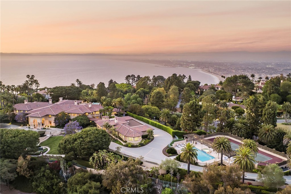 Designed with Feng Shui principles inside and out, this spectacular 34,143-square-foot residence
spans two stories of exceptional living, entertaining and recreational spaces, including 12 bedrooms
and 19 full baths guesthouse and extravagant grounds with koi pond, multiple entertaining
areas, a resort-sized swimming pool and tennis court.
Drama meets detail upon entrance to the home, its soaring double-staircase foyer, flanked by
sumptuous private offices, setting the tone for a grand interior of drama of lavish marble, Feng Shui
motifs, rich mahogany and metallic-gold accents alongside six fireplaces, floor-to-ceiling French
doors, stately stone columns, ravishing chandeliers and intricate architectural ceilings throughout.
The primary suite with fireplace defines sublime with two sitting areas, a drink station, lounge room
with corner desk and his and her private offices, along with an elaborate spa bath featuring a massive
marble soaking bathtub, dual vanities and sinks, in addition to a sauna, steam shower, and workout
area, plus five walk-in closet rooms. A stunning fireplaced formal living room, wrapped in glass with
an adjacent service bar, complements the opulent formal dining room with seating for 16-plus. A
statement in rich red hues, the gourmet kitchen with butler’s pantry/prep kitchen gleams supreme,
highlighting two giant islands with four sinks, extensive Thermador professional appliances, a
Gaggeneau electric oven, indoor grill, Sub-Zero fridges and more.
Along with a rec room with sunken bar, lounge area and adjacent movie theater room are basement-
level luxuries including a two-lane bowling alley, dojo, gym and sophisticated nightclub with bar
seating and sound-equipped DJ booth. An orchestra mezzanine, beauty salon, private telephone booth,
coat closet, housekeeper’s area, and house manager’s office, plus two elevators and an eight-car
garage round out the amenities.
Manned by a security gate and unparallel in privacy and appointments, this property is an opportunity
of truly grand proportions.