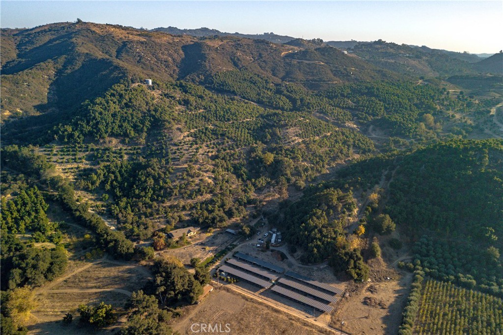 Commanding a total of 66.86 gross acres across five legal parcels, this expansive agricultural property offers a rare combination of scale, infrastructure, and potential. With an estimated 7,500 Hass Avocado trees, three active agricultural wells producing a continuous 500 GPM, and a fourth proven well yielding over 400 GPM, water supply is both abundant and reliable. A 2” public water meter is also in place (not currently in use), complemented by a 55,000-gallon water storage tank and a reverse osmosis system for enhanced water quality. Powering the operation is a robust solar array comprised of 1,080 panels (305 watts each) across six ground-mounted racks—providing sustainable energy to support large-scale farming or future development. This is a turnkey setup for serious growers or investors seeking a high-capacity agricultural asset with exceptional infrastructure in place.