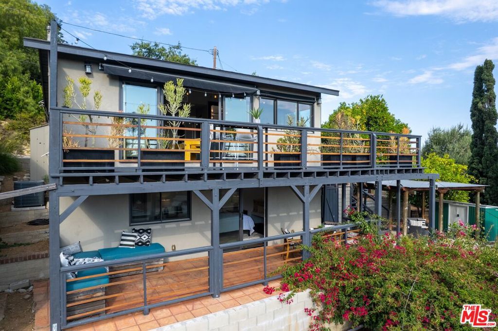 Situated in prime Highland Park, you will find this picturesque 2 bed 2 bath 1920's 2-story Craftsman Bungalow, perched up in the hills of a quiet street North of York Blvd. This property is quintessential indoor/outdoor California living. A hillside property with multiple decks, patios, levels, and outdoor areas create a private, tranquil urban retreat. You are welcomed into the main living space, with beamed vaulted ceilings, abundant natural light from multiple windows & slider doors opening onto a large wrap-around deck, offering unobstructed views of our gorgeous SoCal sunsets and the surrounding hillsides. The living room effortlessly flows out to the deck with a smartly positioned retractable awning. The second bedroom on the first level with lots of natural light, own large closet space with a separate entrance and stacked W&D. The multiple levels of the terraced hillside contain empty beds ready for planting vegetables, mature bountiful fruit trees, tranquil hot tub, and outdoor dining/relaxing space. From the living room, head on down to the lower level and there you will find your primary suite which opens to its own large private patio with sights of beautiful bougainvillea and lush hills. Venture all the way down the steps to the cul-de-sac on Ave 53 and you find a separate entrance and a converted garage that's your perfect art studio/office/bonus room. Other updates and some hidden gems are 3 storage sheds, retractable awning, HVAC, modern electrical with upgraded 220 panel, copper plumbing, lots and lots of handy cabinets and closets. Stunning new quartz kitchen countertops, new appliances, checkered tile floors and the completely remodeled full guest bath with vintage green tile perfectly match the original bungalow aesthetic.