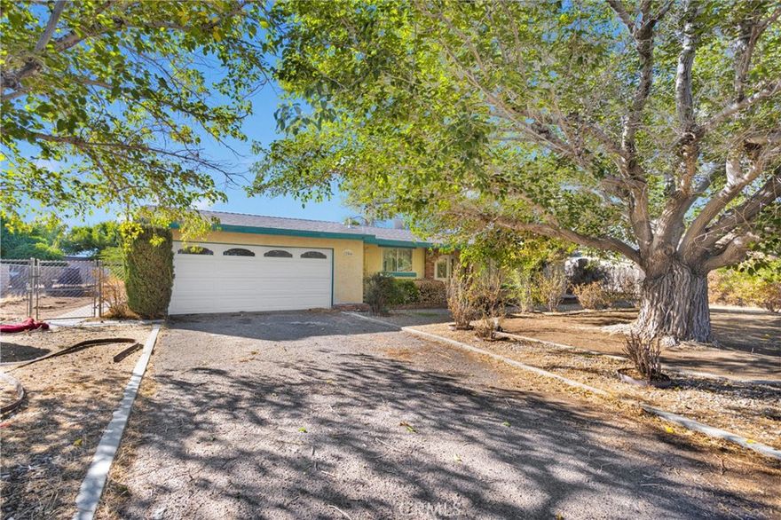 Welcome to 12566 Iroquois Road in the heart of Apple Valley. On nearly half an acre surrounded by mature trees and a great neighborhood vibe. This 3-bedroom, 2-bath home features a bright kitchen with granite counters, newer white cabinets, stainless steel appliances, and tile flooring that ties it all together. The living room offers a cozy fireplace and plenty of natural light, perfect for relaxing or entertaining. Step outside to a spacious backyard with a large covered patio which is great for BBQs, family gatherings, or just enjoying the desert evenings. There’s also an attached 2-car garage and lots of space for extra parking or future RV access. You’ll love the location, close to schools and just minutes from Jess Ranch Marketplace, the High Desert’s most popular shopping destination, with the new Sprouts, coming soon Hobby Lobby, and Five Below all nearby. A great home, a great lot, and a prime spot in Apple Valley at a great price, this one checks all the boxes.