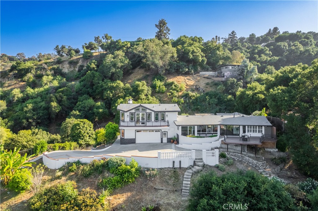 Experience Resort-Style Living in this Move-In Ready Luxury Estate with Breathtaking Panoramic Views in Prestigious Turnbull Canyon! Step into your private hillside retreat nestled in the sought-after Hacienda Heights neighborhood, where every detail reflects the elegance and comfort of a five-star hotel. This fully remodeled 2,727 sq ft home blends sophisticated style with seamless indoor-outdoor living, all set against stunning, unobstructed views of rolling hills, twinkling city lights, and majestic mountains. Enter through a dramatic 20’x8’ California bifold glass door, where natural light floods the open-concept space, creating an inviting, airy ambiance. The home’s sleek commercial-grade luxury vinyl tile flooring—featured in high-traffic stadiums—ensures durability and elegance throughout. The expansive living area, centered around a striking 60” fireplace wrapped in Italian Calacatta marble, boasts soaring ceilings and recessed lighting, perfect for both grand entertaining and cozy evenings. The chef’s kitchen features top-of-the-line appliances and finishes, delivering both beauty and performance worthy of a luxury estate. It includes a Subzero refrigerator, 5-burner F.lli Bertazzoni stove, Viking cooktop with built-in wok grill, Wolf oven, LG Smart Inverter microwave, and custom cabinetry. A cozy dining nook is perfectly positioned to capture panoramic views. Retreat to the lavish primary suite, a spa-like sanctuary with vaulted ceilings, huge windows framing sweeping views, custom closets, and a bathroom finished in Italian marble with golden bronze accents. Indulge daily in your private wellness escape with a jetted soaking tub, dual steam and rain showers, two-person sauna, and Toto bidet—luxury living redefined. Integrated surround sound, LED and recessed lighting, and stylish touches like a custom solid wood barn door elevate the home’s ambiance. Outside, the serene backyard offers year-round enjoyment with a large deck, full outdoor kitchen with BBQ and teppanyaki grill, heaters, and cozy fireplace—ideal for relaxing or entertaining in style. Additional amenities include a fully fenced property with fruit trees, home gym, epoxy-finished garage with built-in storage, upgraded electrical and plumbing, ADT alarm system, and a dedicated K-9 kennel/shed for pets. This exquisite estate offers the ultimate move-in ready experience—combining impeccable design, panoramic views, and resort-caliber comforts to make every day feel like a luxury getaway