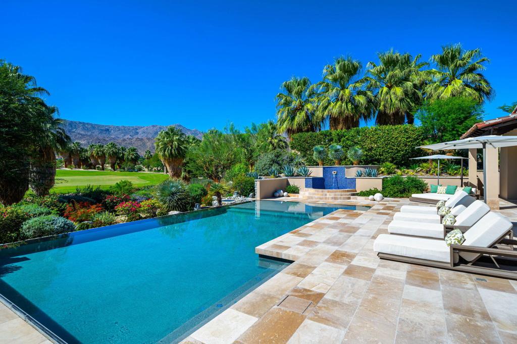 Welcome to this extraordinary custom estate, perfectly positioned along the 11th green of the Canyons course at the renowned Bighorn Golf Club. Recently reimagined with impeccable taste, no expense was spared and no detail overlooked in its transformation.A private gated courtyard leads to a dramatic great room crowned by a vaulted ceiling, where steel-framed French doors open to a limestone terrace and pool. From here, sweeping vistas of the Tom Fazio-designed fairways and the rugged San Jacinto Mountains create a breathtaking backdrop. The great room flows effortlessly into the dining room, anchored by an exquisite double-sided fireplace, and onward into a striking Bultaup-designed kitchen and family room. The gourmet kitchen, outfitted with top-tier appliances, features a warm banquette for casual gatherings.Offering five bedrooms, including a detached casita, the home is designed for comfort as well as grandeur. The Primary Suite is a serene retreat with its own fireplace, expansive dressing room, and spa-like bath featuring a limestone soaking tub and steam shower with both wall-mounted and rainfall fixtures. For entertainment, a custom-designed theater with an 11-foot screen, digital projector, and acoustically tuned interiors provides a cinematic experience.Spanning 6,617 square feet, the estate celebrates desert living with a vast outdoor sanctuary complete with a full kitchen, covered dining, fireplace, television, pool, spa, and outdoor shower. Smart-home technology enhances the ease of everyday living, with custom furnishings, included per inventory, complete the offering.This is not simply a residence, but a refined desert retreat and exceptional home where architecture, luxury, and lifestyle converge. Bighorn membership available separately.