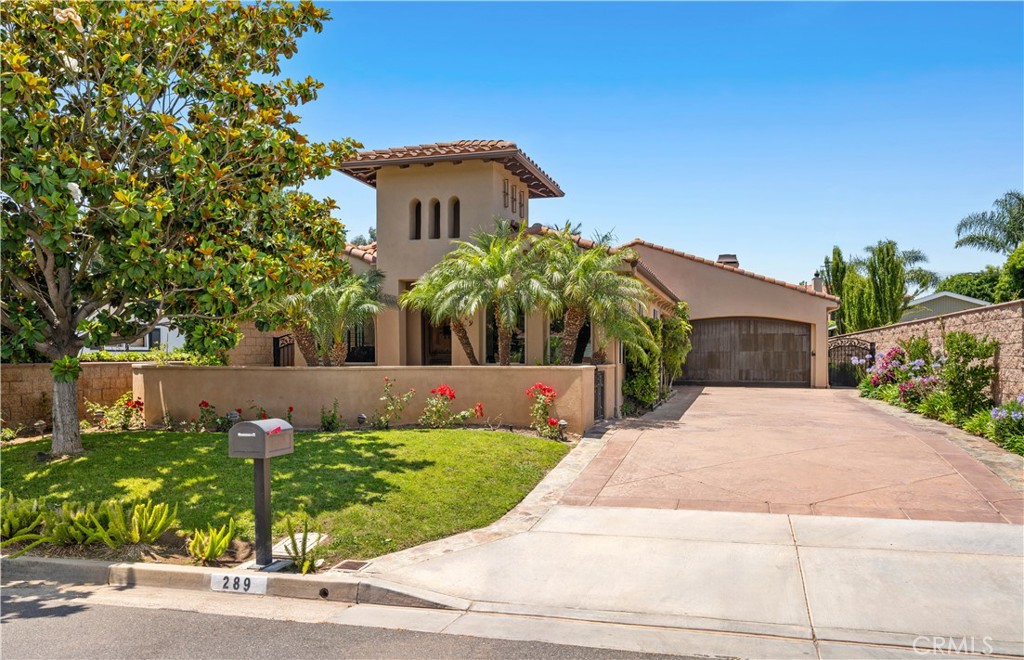 The Spanish Colonial beauty of 289 23rd Street is easily matched by its functionality and ideal location, nestled within highly-coveted Eastside Costa Mesa. This elegant 4-bedroom, 3-bathroom home sits tucked away from the street offering privacy and flexibility with timeless architecture, refined upgrades, and a sophisticated coastal lifestyle. The home’s charming curb appeal, lush landscaping, and spacious front patio complete with fire pit set a warm and inviting tone. Step through the handcrafted wood front door into a light-filled interior where vaulted ceilings, oversized picture windows, and custom finishes create a serene atmosphere. The heart of the home is the chef’s kitchen, complete with rich maple cabinetry, granite countertops, premium stainless steel appliances, and a spacious island with bar seating — perfect for entertaining or everyday living. The adjoining formal dining room and cozy living room with custom built-ins and a fireplace provide comfortable yet elevated spaces for gathering. A true retreat, the oversized primary suite features its own fireplace, spa-like bath with soaking tub, walk-in shower, seated vanity, expansive closet, and access to the tranquil backyard. Three additional bedrooms, one over-sized with its own fireplace and backyard access, and dedicated home office offer flexibility for families, guests, or remote work. Step outside into your private backyard oasis, thoughtfully designed for alfresco living. A generous spa, outdoor grill, veranda, and spacious patio invite year-round dining and relaxation under the stars. A large laundry room, 2-car garage and small pool house round out the property. Ideally located near Newport Back Bay trails, world-class beaches, popular shopping and dining on 17th Street, and top-rated schools, 289 23rd Street offers the perfect blend of architectural charm, modern comfort, and coastal convenience – all in the heart of Eastside Costa Mesa.