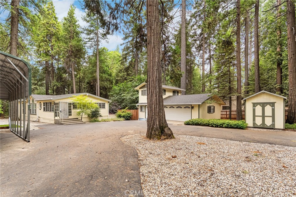 First time on the market! Tucked away on over an acre, this beautifully landscaped and secluded property offers 2 bedrooms, 2 bathrooms, a dedicated office, and a detached garage with a loft, half bath, and bonus guest space. Enjoy a spacious open floor plan with soaring ceilings, large windows, and a cozy gas fireplace in the living room. The kitchen features quartz countertops, a pantry, and newer appliances perfect for both everyday living and entertaining. The primary suite is a peaceful retreat with dual sinks, a garden tub, walk-in closet, and generous space. You'll also find an updated guest bathroom, a second bedroom with a walk-in closet, and a bright office for remote work or hobbies. Step outside through the French doors to a large deck with an awning, overlooking the fully fenced backyard with lush lawn, pergola, big shed, and mature landscaping. Other highlights include a newer Generac generator, newer HVAC system (replaced 5 years ago), and all the privacy you’ve been looking for.