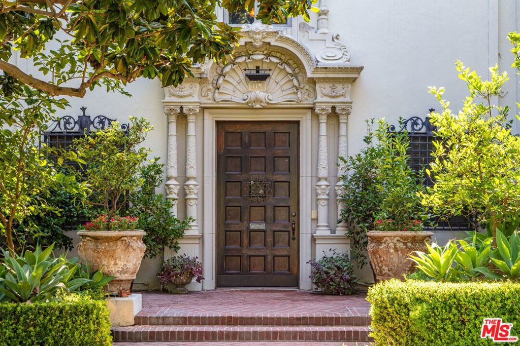 Fremont Place: a park-like gated community in Hancock Park, home to celebrities, government officials & entrepreneurs. An elegant entrance of cast concrete columns greets residents. Set back from the street & surrounded by mature landscaping for utmost privacy. Step inside to a stunning 2-story entry; continue to the formal living room w/dramatic double height wood beamed ceilings & large fireplace. A gorgeous sunroom overlooks a lush courtyard & fountain. Grand 2-story ballroom doubles as a home theater. A lavish dining room w/coffered ceiling is perfect for dinner parties. Main level also includes a gourmet chef's kitchen w/walk in pantry, breakfast room & guest suite. Second level includes a screening lounge, primary suite w/large walk in closet, spa like bathroom & custom blue themed guest suite. Includes detached guesthouse, gym, loggia, outdoor dining, pool & spa. This is truly a one of a kind estate that can't be duplicated. A rare chance to own a piece of Hollywood history.
