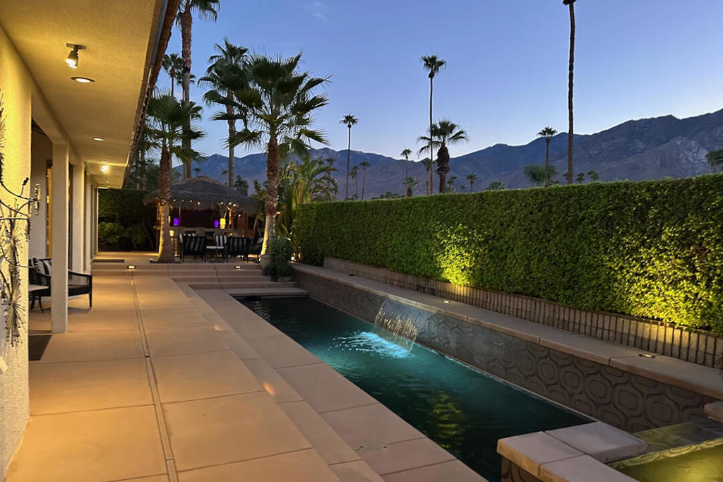 This beautifully remodeled property offers a luxury living experience, blending modern elegance with Polynesian-inspired flair. This immaculate, four-bedroom home is on fee land in the sought-after Indian Canyons neighborhood in South Palm Springs. Its open living room and dining area boasts vaulted and beamed ceilings. A wall of windows and doors to the backyard highlights the pool and panoramic mountain views. The main entertaining area also has a wet bar and an adjoining media room.The designer kitchen is a masterpiece centered around an oversized prep island with dine-in seating. This gourmet space showcases custom cabinetry, premium high-end appliances, and abundant room for entertaining family and friends. Fleetwood sliding doors lead directly to an outdoor paradise featuring a luxurious tiki bar, Polynesian-inspired pool with spa, and outdoor kitchen.The primary suite is a retreat that features a cozy sitting area with a gas fireplace, direct poolside access, a generous en ensuite bathroom, and a Sex in the City worthy walk-in closet. Additionally, the home provides three more comfortable bedrooms--two of which include their own ensuite bathrooms. The home has leased solar and the convenience of an attached two-car garage.Bedrooms | Total 4 | 3 bedroom suitesBathrooms | 4 Total | 3 ensuite and a guest bathInterior size | 3,338 sqftLand | Lot size 12,197 sqft Fee Land - you own the landBuilt | 1990Parking | Attached 2-car garageLeased Solar | $326 per month | Installed 2018 | 52 panels; 18.72 direct current; 17.97 alternating currentAdditional Items and Amenities: Pool equipment installed in 2018 Two HVAC systems installed in 2020 Two on demand water heaters installed 2018