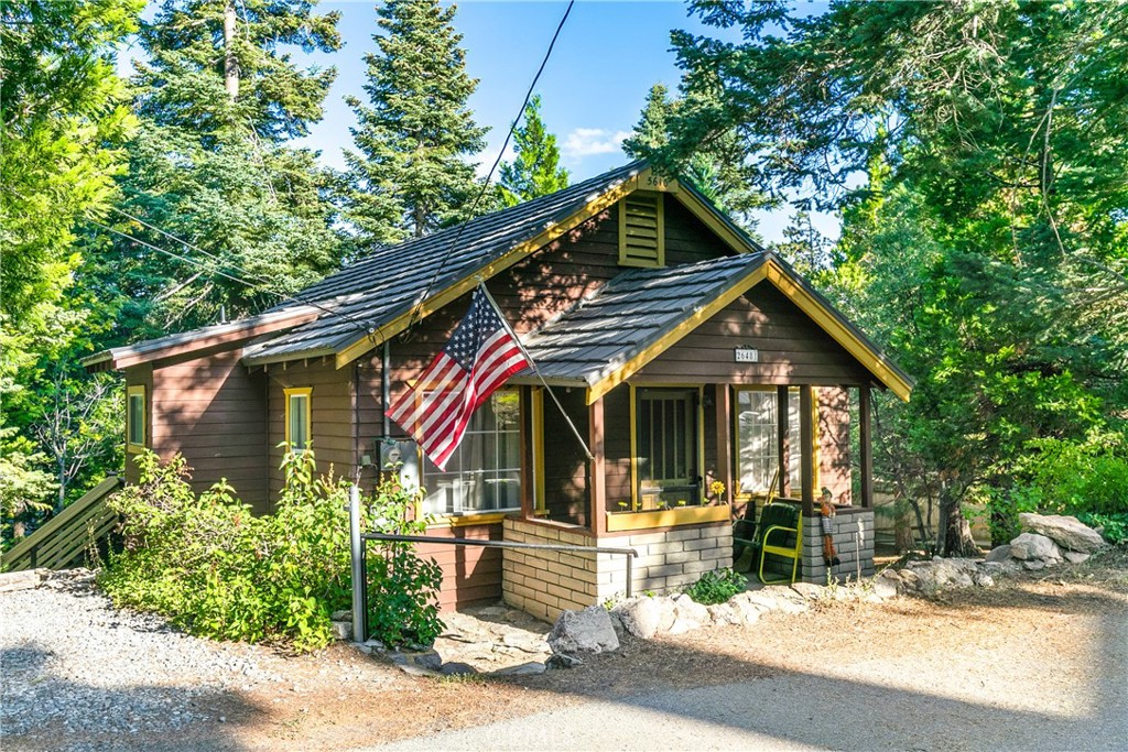 Seller has done alot of work! Pest, chimney and roof repairs and sewer main replaced! Welcome to the vintage stye, with modern upgrades, lovingly updated by the owner over the years. Nestled on approximately 0.23 acres and surrounded by cedar, apple, and dogwood trees ~ this home offers the perfect mix of nature, comfort, and character. From the covered front porch enter the spacious living room complete with a cozy fireplace and stunning wood paneling made from reclaimed bark beetle wood – a unique and rustic touch. A bedroom, fu bath, and versatile spare room—perfect for guests, a home office, or hobby space. The open dining area connects to a well-appointed kitchen, which leads out to a private back deck for relaxing or entertaining in the shade of the cedars. Modern updates include dual-pane windows, newer paint and decking, a new forced air unit (FAU), aluminum shake roof, and air conditioning for year-round comfort. Do not miss the finished basement, with a separate entrance, is a workshop and laundry area—ideal for DIY projects or extra storage. Plenty of usable outdoor space around the cabin offers even more potential, whether for gardening, recreation, or just soaking up the serene mountain atmosphere. Don’t miss this cozy and unique retreat—move-in ready and waiting for you!