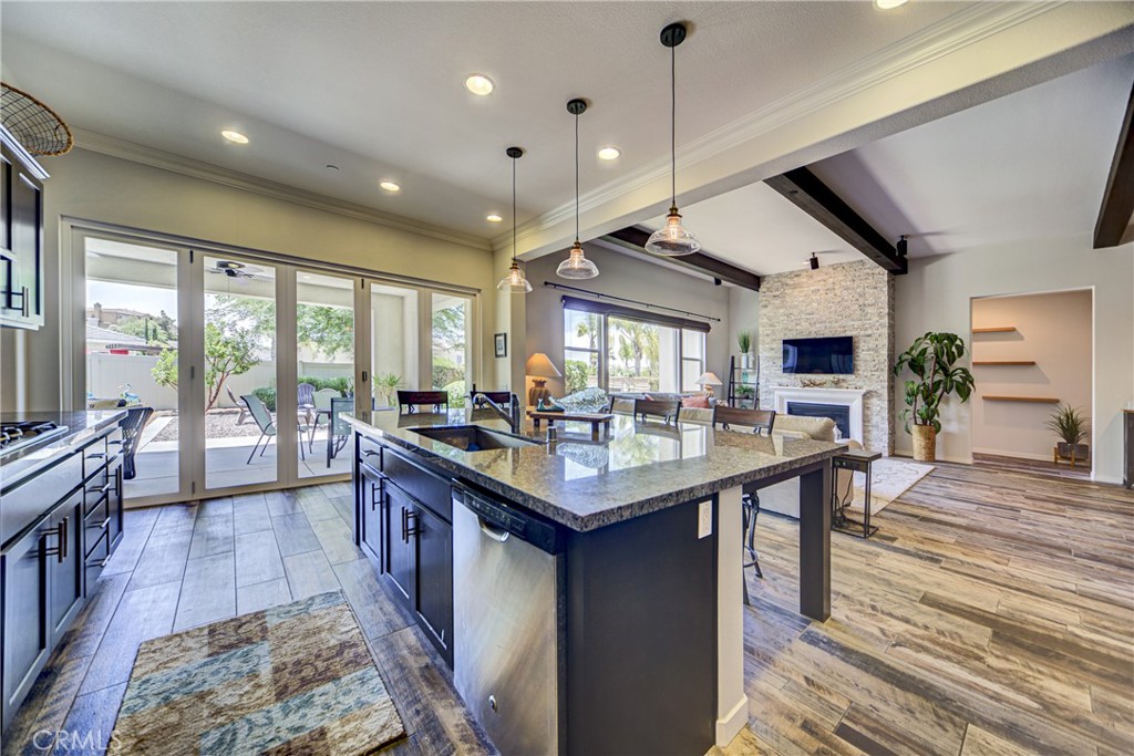 Executive single story with two master suites and a large yard with a California Room and three car garage. Highly upgraded great room with beamed ceilings, stone accent fireplace wall and bi-fold doors to the California room. When you enter the house there is a huge entry way, with a dramatic chandelier, which opens to the living area which showcases upgraded wood-like tiles throughout, and beamed ceilings in the great room and dining room. Better than new with shutters throughout as well as crown molding. The kitchen sports a huge eat at island and opens onto the California room through bi-fold doors. There is another room off the kitchen which is currently set up as a pool room, but could be a gaming room or office. There is also a massive pantry and laundry room with a sink as well as a half bathroom. The master suite features a slider to the backyard spa area. The bathroom has a custom tiles separate tub and shower as well as double sinks and a walk in closet. For maximum privacy and convenience there are two separate bedroom wings from the formal entryway. There is a junior master suite with a walk in closet and a bathroom with a walk-in shower in the one wing The second wing has two spacious bedrooms with walk in closets and a shared secondary bathroom. The front yard has just been landscaped with low maintenance plantings for easy maintenance with low water usage. The beautifully landscaped yard has a spa and fire pit as well as beautiful landscaping and the California room. There is a three car tandem garage.