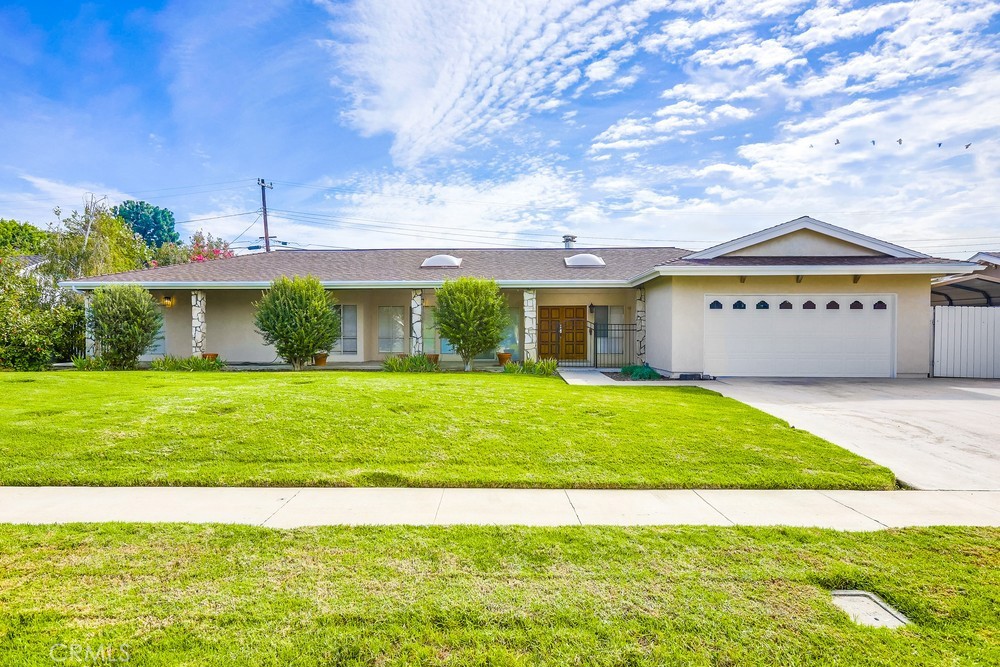 Welcome to your dream home in the heart of North Tustin! This exquisite SINGLE-STORY, 4-bedroom, 2-bathroom residence on A 11,700sqft LOT offers the perfect blend of comfortable living, convenient access, and picturesque surroundings. Situated in the highly sought-after neighborhood of North Tustin, this home is a unique opportunity to be part of the growing North Tustin community. As you enter, you'll be greeted by a spacious and inviting living room with plenty of natural light from the FLOOR TO CEILING WINDOWS. The open floor plan seamlessly connects the Kitchen, Living Room, and Family Room, making it ideal for entertaining friends and family wherever you like. The kitchen is a dream for any chef, showcasing sleek stainless steel appliances, a spacious island with a built-in range, generous counter space, custom cabinetry, and a WALK IN PANTRY. This home offers four well-proportioned bedrooms, providing flexibility for a home office, guest room, or additional living space—each designed for both comfort and functionality. Standout features of the Primary Bedroom include a dual aromatic-cedar lined walk in closets, a glass enclosed large shower, jetted tub,a and LED MIRROR. Step outside the kitchen and living room to a large, covered, WRAP AROUND PATIO with wood deck and a natural gas FIRE PIT—perfect for entertaining or relaxing. The beautifully maintained yard and raised planter beds full of iceberg roses frame panoramic views of the Tustin Foothills, the Santa Ana Mountains, and Santiago Peak—the highest point in Orange County. The front and back yards are thoughtfully landscaped, offering ample space for outdoor activities, gardening, or simply unwinding won the large front and back patios. A two-car garage, an OVERSIZED DRIVEWAY, and a covered 10' x 20' side yard provide abundant room for parking and storing vehicles, tools, and toys. Recent improvements include replaced sliding glass doors off the kitchen and living rooms, as well as a NEWLY INSTALLED and permitted 200amp solar-ready electrical panel.