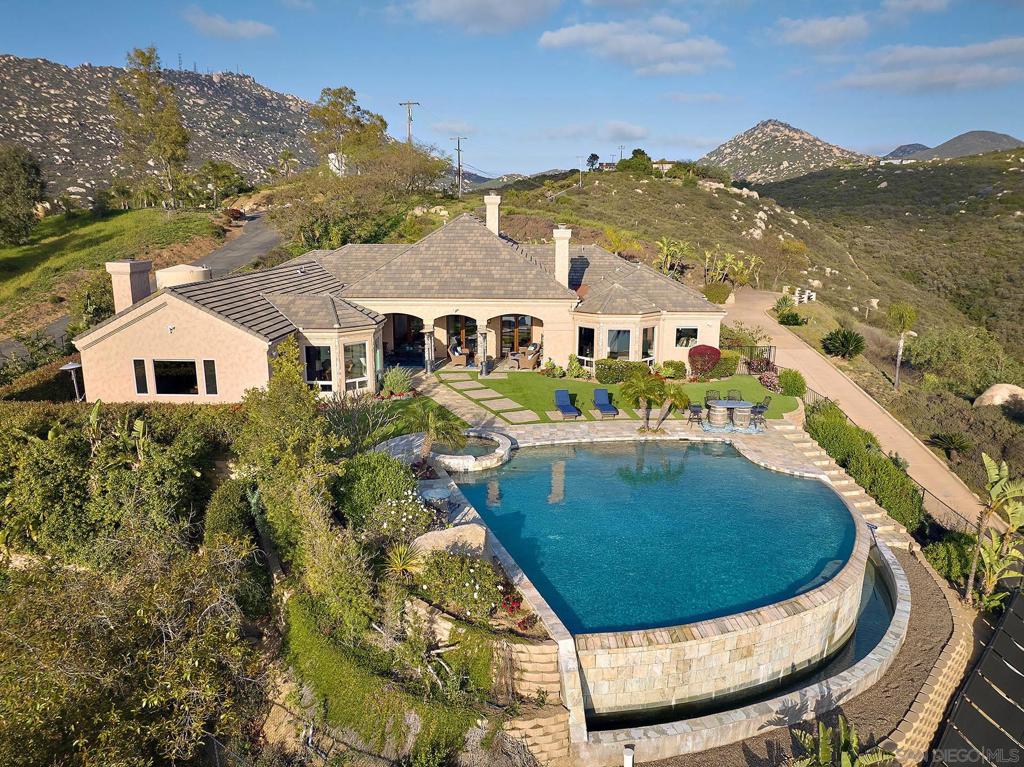 Finest Estate on the Market! When only the best will do! Welcome to this breathtaking private single-level estate designed for luxurious living and effortless entertaining set on over 2.86 acres. This exceptional 4-bedroom, all ensuite residence features a rare private office and an expansive game room/bonus room, offering both functionality and indulgence. Step outside to a resort-style vanishing-edge pool and spa, and a charming outdoor loggia with a fireplace—perfect for intimate gatherings. Enjoy panoramic sunset and ocean vistas on a clear day from the open-concept great room and casual dining space, where natural light enhances every moment. The designer kitchen is a chef’s paradise, featuring an oversized island with dual sinks and plenty of counter seating seating, dual dishwashers, a 6-burner gas range with grill, dual ovens, large built-in side-by-side stainless refrigerators, and a walk-in pantry, creating the perfect space for family dinner parties. The lavish primary suite boasts a grand fireplace and an inviting sitting area, all framed by stunning views, a generous primary bath with plenty of counter space and make up area, walk in closets, custom tiled shower and soaking tub. Served by a robust photovoltaic solar system, pool solar heating, a 5000 gallon storage tank, artificial turf and a raised garden bed. This estate blends elegance, comfort, and impeccable style—your dream home awaits! When only the best will do. Welcome to this breathtaking private single-level estate designed for luxurious living and effortless entertaining set on over 2.86 acres. This exceptional 4-bedroom,all ensuite residence features a rare private office and an expansive gameroom/bonus room, offering both functionality and indulgence. Step outside to a resort-style vanishing-edge pool and spa, and a charming outdoor loggia with a fireplace—perfect for intimate gatherings. Enjoy panoramic sunset and ocean vistas on a clear day from the open-concept great room and casual dining space, where natural light enhances every moment. The designer kitchen is a chef’s paradise, featuring an oversized island with dual sinks and plenty of counter seating seating, a 6-burner gas range with grill, dual ovens, large built-in side-by-side stainless refrigerators, and a walk-in pantry, creating the perfect space for family dinner parties. The lavish primary suite boasts a grand fireplace and an inviting sitting area, all framed by stunning views, a generous primary bath with plenty of counter space and make up area, walk in closets, custom tiled shower and soaking tub. Served by a robust photovoltaic solar system, pool solar heating, and an active well with5000 gallon storage tank provide a favorable utility profile. This estate blends elegance, comfort, and impeccable style—your dream home awaits!