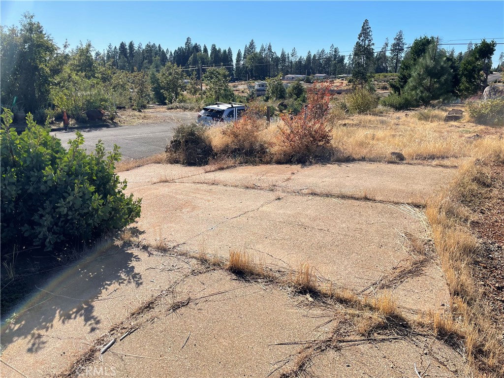 This is  level lot with a view.  A house with a 2/2 was formally built on this lot and was cleared after the Camp fire. It is on a cul-de-sac and is in the PPOA with access to summer swimming, hiking trails and a clubhouse. There is a circular driveway for convenience!