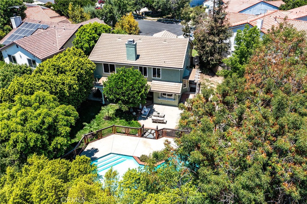 TO SEE VIDEO VIRTUAL TOUR: If you do not see a video icon or link, copy and paste address into search field of YouTube.com.
Located on a quiet cul-de-sac in one of Chatsworth’s most desirable neighborhoods, 20516 Germain Avenue is just a short walk from shops, dining, restaurants, and the beautiful Mason Park and Recreation Center, which features baseball diamonds, outdoor basketball courts, a splash pad, playground, picnic areas, a kitchen, and stage for community events. Beyond dramatic double doors with stained glass, this fully remodeled 4-bedroom plus office loft home offers exceptional indoor and outdoor living on an expansive, private lot. A downstairs bedroom with its own entrance and an adjacent full bath is perfect for guests or multi-generational living. The custom kitchen is a chef’s dream, featuring underlit cabinetry, quartz countertops, a 48” Viking gas range with dual ovens, six burners, a stainless flat-top griddle, Viking range hood, 36” Viking refrigerator, built-in microwave with warming drawer, farmhouse sink, and wine fridge. Enjoy soaring 20-foot ceilings in the dramatic living room with a brick-lined wood-burning fireplace, while the formal dining room and kitchen eat-in area open through French doors to a spacious side yard and cabana patio. The upstairs includes three generously sized bedrooms plus an open office loft with built-in cabinetry and quartz countertops, overlooking the living room below. The expansive primary suite includes multiple closets, light-up defogging mirrors, and a luxurious bath with dual pedestal sinks and a walk-in shower. The upstairs guest bathroom features dual sinks with custom cabinetry and quartz countertops. All bathrooms are thoughtfully updated with modern fixtures and finishes.
Outdoors, enjoy a huge backyard oasis with an irregularly shaped pool featuring a large shallow area, spill-over waterfall Jacuzzi, custom pool fence, gazebo, and lush mature trees for added privacy. A beautifully finished garage completes this exceptional home.