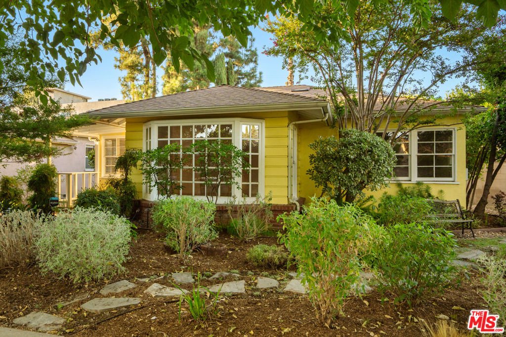 An enchanting cottage residence located on a quiet tree-lined cul de sac in Sherman Oaks, this is the perfect home in which to add one's personal touches! A mature Fruitless Mulberry and a wall of Cypress trees provide a private garden-like feel as one approaches the home via the brick walkway. Upon opening the front door, one is greeted by a spacious living room and charming bay window offering an abundance of natural light showcasing original honey colored hardwood floors found throughout the home. Original window shutters offer privacy in the dining area which is a perfect spot to enjoy a meal with family and friends. An expansive galley kitchen features tiled counters, custom tiled backsplash, and ample cabinet space in which to prepare and store cooking supplies. Frosted glass cabinets and pull-out drawers offer additional storage while the kitchen door opens to a patio with custom-built pergola and a backyard made for entertaining, featuring a meandering flagstone path and pavers. Glass shelf built-ins line the hallway leading to the generous sized three bedrooms all with hardwood floors and closets with built-in shelving and drawers. The bathroom features a pedestal sink with tiled backsplash and a charming glass-doored farmhouse medicine cabinet. The back bedroom opens out to the expansive backyard with mature trees offering privacy and shade. An inviting covered patio and flat backyard space can be reimagined for year-round entertaining and room for a pool. The landscaping is equipped with in-ground watering system and drip lines located in the front and back of the property. A detached garage offers the option of additional storage and could be used for lifestyle amenities if extra space is desired. This is the quintessential home in which to expand and make your own.