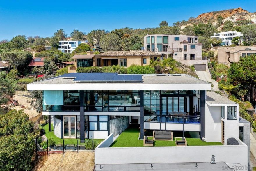 Perched high above the coastline, 12911 Via Grimaldi delivers sweeping whitewater, lagoon, and sunset views that capture the very best of Del Mar living. Walls of glass frame the Pacific from nearly every room, blending sleek modern design with the natural beauty of the coast.  At the heart of the home, the chef’s kitchen stuns with clean lines, luxury appliances, and an oversized island oriented perfectly toward the ocean—so even meal prep comes with a view. Designed for both everyday living and effortless entertaining, it’s a space where form meets function in the most inspiring way.  Spacious open-concept interiors flow seamlessly to expansive decks, creating the ultimate indoor-outdoor retreat. Beyond the home, endless adventure awaits—whether it’s a morning hike through the dramatic trails of Torrey Pines State Natural Reserve, a day on the sand at Del Mar Beach, or dinner in the Village just minutes away.  Watch the waves roll in and the sun dip below the horizon—all from your own vantage point above the sea. This is more than a home; it’s a modern coastal sanctuary where every detail celebrates the view.