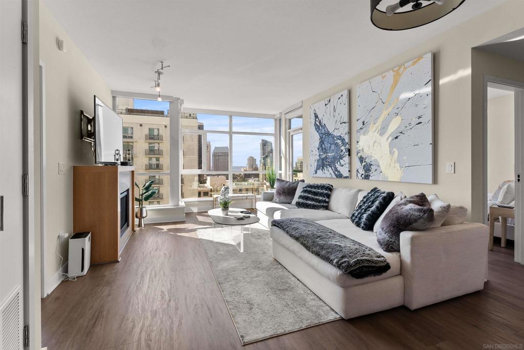 Welcome to Unit 1507 at The Legend, where downtown San Diego living reaches new heights. This exceptional two-bedroom, two-bath corner residence combines modern luxury with unbeatable convenience in one of East Village's most sought-after addresses. Natural light pours through floor-to-ceiling windows adorned with custom treatments, illuminating beautiful hardwood floors and highlighting the home's thoughtful design. The gourmet kitchen impresses with granite countertops, premium cabinetry, decorative tile backsplash, and top-of-the-line stainless appliances—ideal for both everyday meals and entertaining. Your private balcony showcases captivating western views, creating the perfect backdrop for morning coffee or evening wine as you watch the sun dip below the horizon. The generous primary bedroom offers a serene escape with an oversized walk-in closet and luxurious ensuite bath featuring double sinks and elegant tile finishes. Practical luxury continues with climate-controlled comfort, two dedicated parking spaces, and additional storage space. The Legend's resort-caliber amenities are truly exceptional: take a dip in the sparkling pool, unwind in the spa, steam room, or sauna, and stay fit in the state-of-the-art gym. The spectacular rooftop deck features fire pits, grilling stations, and a full kitchen with stunning Petco Park views. Plus, enjoy private 7th floor deck access—perfect for catching Padres games and concerts right from home. Location doesn't get better—walk to Petco Park, explore trendy restaurants and coffee shops, or enjoy quick access to Balboa Park!