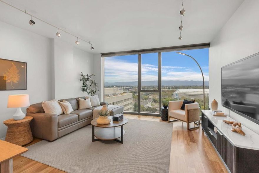 Located on the 18th floor, this unit offers sweeping west-facing sunset views through dramatic floor to ceiling windows that fill the home with natural light. Enjoy the convenience of one touch roller shades in both the living room and bedroom. The bedroom includes a ceiling fan and a dedicated office or den, one of the most sought after layouts at AXIS. The flexible bonus space also works well as a fitness area or creative corner. The kitchen features stainless steel appliances with plenty of room for bar seating and a dining area that can comfortably host six to eight guests. Additional highlights include an in unit washer and dryer and one assigned parking space on B2 space 196. AXIS provides premium amenities including a fitness center on the second floor, a refreshed pool and Jacuzzis, and beautifully designed barbecue areas and fire pit seating on the third floor. These spaces create the perfect setting for relaxing or entertaining. Situated in the heart of downtown San Jose, you are just steps from San Pedro Square, array of Cafe's, the SAP Center, farmers markets, light rail, and Diridon Station. Experience elevated urban living at AXIS.