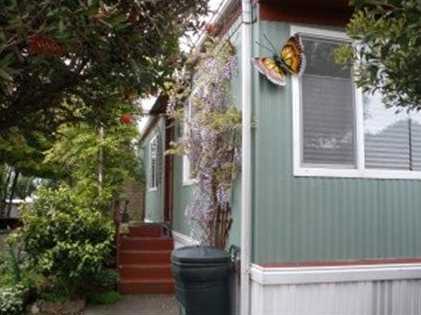 Coastal living at an affordable price.Come see all this mobile home has to offer. This 2 bed 1 bath home features an open concept kitchen/dining/living room that has tiled kitchen floor and laminate flooring throughout the home. Large master bedroom with a walk in closet. Extend the indoor living to outside with a huge yard with fire pit, green house, apple tree and lemon tree along with artichoke plants. The possibilities are endless.