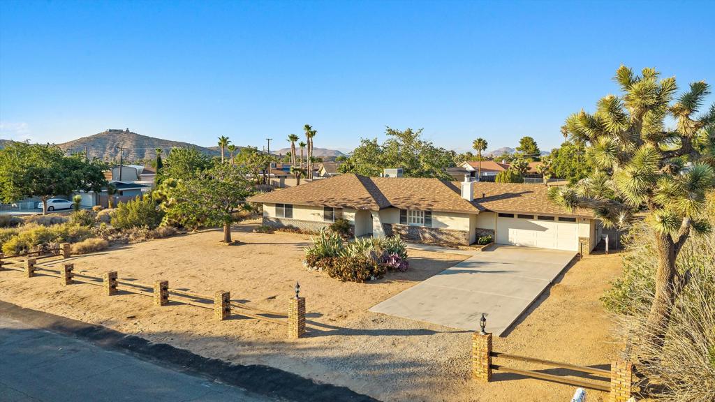 Introducing for the first time on the market, this ranch-style gem, located in the coveted Sky Harbor neighborhood of Yucca Valley. Nestled on a sprawling 20,600 square foot lot, with 1,487 square feet of living space, this charming 3-bed, 2-bath home with attached 2-car garage (and RV Parking) offers plenty of room for your creative endeavors or just relaxing in your own personal sanctuary. Step inside to discover a land where carpet reigned supreme, and can be found throughout, including both the kitchen and primary bathroom, in all its original, well-cared-for glory. The large living room invites you to unwind in front of its charming fireplace, providing an ideal setting for gathering with friends and family. This home is as clean as a whistle and ready to host your next chapter. Fear not the desert heat, as the newer central AC is here to keep things cool and breezy. And while the home's vintage allure is a nod to yesteryear, the potential for personal touches and updates is begging for you to add your unique flair. Cease the opportunity to live in a home in a great area that celebrates both history and potential, while soaking in the stunning mountain vistas.