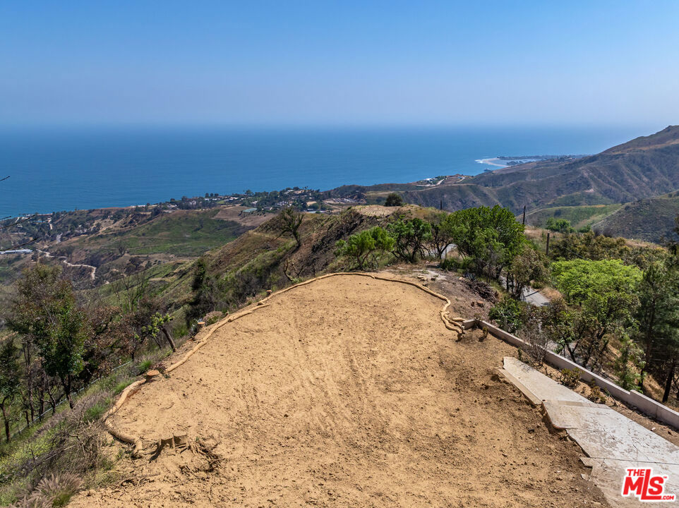 Seize this rare expedited rebuild opportunity on a 4.5-acre promontory lot in the heart of Malibu, showcasing stunning 280-degree ocean and coastline views, from Santa Monica Bay to Catalina, Malibu Pier, Surfrider Beach, and Malibu Lagoon. This expansive fire burnout parcel presents limitless potential to create your bespoke ocean view estate. Preliminary conceptual plans by Vitus Matare & Associates outline a 3,276 sq.ft. main residence with 3 bedrooms, 3 bathrooms, and an office, alongside a detached 706 sq.ft. studio, a 778 sq.ft. secondary studio, a detached 2-car garage, carport, and a pool. Ideally located, this property is just 6 minutes from PCH, 10 minutes to Nobu and Soho, and 15 minutes to Cross Creek's Country Mart, offering the perfect balance of tranquil privacy and proximity to Malibu's premier dining and shopping.