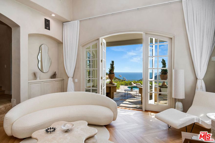 Introducing Cumbre Alta, where elegance and excellence come together in a stunning and dramatic architectural display that will take your breath away. This Architectural Digest featured home boasts unprecedented Pacific Ocean and canyon views, nestled on a cul-de-sac for ultimate privacy and located in the exclusive Highlands. This is the luxurious oasis you have been waiting for. As you enter the captivating foyer with soaring ceilings, a beautiful grand staircase greets you and creates a winding eye's delight in the Scandinavian inspired home. Designer Elisa Baran Trean shaped the gorgeous home into a masterpiece, coupled with the home's unmatched and effortless indoor/outdoor al fresco balconies. Beautifully new renovated herringbone floors in formal living room, new office floors, natural stone bar and accent stone walls, lime washed walls through entire house, new speak easy door that leads to basement, completely remodeled grand wrap around spiral staircase and wood flooring on staircase, new buffet stone cabinetry at formal dining room, and completely remodeled secondary upstairs bathrooms with stone sinks, custom shelving and new custom lighting throughout including one of a kind chandeliers. The grounds are lush with fruit trees and your own garden, overlooking the shimmering Pacific Ocean- located on the trophy lot in Pacific Palisades Hills- the developer himself called Cumbre Alta home once because of the home's incredible position and views. Step into opulence as you enter the formal living and dining room with ocean views. Designer chef's kitchen is an entertainers dream come true, with state of the art appliances, wine fridge and warm, spacious breakfast area overlooking the balcony and sparkling pool. Enjoy the lush garden and fruit trees while relaxing on the green grass surrounded by the gorgeous Canyons. Enjoy the interiors' first floor formal office, ensuite bedroom and bathroom and large family room. Bonus basement room -perfect for home gym and a separate nanny staff suite, could also double as a second home office. Upstairs unwind in a beautiful primary suite overlooking the Ocean, with your very own private balcony- enjoy every sunset over the Pacific Ocean and serene canyons. Primary bathroom boasts steam shower and beautiful tub, ready for a relaxing plunge. Two additional large ensuite bedrooms completes the gorgeous upstairs retreat. Enjoy exclusive use of the HOA's beautiful grounds and amenities including pool, jetted spa, tennis courts, 24-hr security patrol- all included with HOA. Residents also enjoy membership access to the gated, dog-friendly Highlands Park. Cumbre Alta will surely leave your guests in awe of its beauty- a true work of art, what more can one ask for!