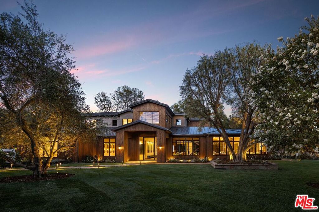 Introducing Three Planes, an extraordinary new 11,000 sq ft modern equestrian estate by acclaimed designer Jae Omar, set on over an acre in the exclusive gates of Hidden Hills. Inspired by the Chumash people and their deep connection to nature, the home is a rare fusion of bold architecture, organic materials, and intentional design. The residence offers 5 bedrooms and 6.5 bathrooms, with the luxurious primary suite and three secondary bedrooms located upstairs, each with its own ensuite bath. A dedicated wellness and entertainment wing features a gym, private spa, media room, wine cellar, and wet bar. The chef's kitchen with breakfast nook and walk-in pantry flows effortlessly to grand living and dining spaces under soaring, beamed ceilings. Outdoors, discover a resort-style pool and spa, firepit, outdoor kitchen, yoga deck, and a detached barn perfectly honoring Hidden Hills' equestrian heritage. Every detail is crafted to inspire, making Three Planes as much an artistic statement as it is a private sanctuary.