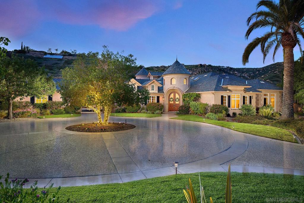 Seize the opportunity to live in Poway’s exclusive, guard-gated community - The Heritage. This timeless French-inspired estate, crafted by acclaimed builder Tony Garzynski, offers luxury living at its finest. Situated at the end of a quiet cul-de-sac and offering breathtaking mountain views, complete privacy, and the ultimate entertainer’s resort. The outdoor space has been thoughtfully designed with a recently remodeled pool featuring a dramatic ambiance w/waterfalls, and fire bowls creating a resort-like atmosphere perfect for relaxing or hosting. A built-in BBQ area with a fireplace makes dining al fresco a year-round pleasure, while the low-maintenance, water-wise landscaping ensures beauty with ease. With fully paid solar panels, two Tesla batteries, and minimal electricity bills, this home combines luxury with smart efficiency. Elegant craftsmanship throughout, featuring Andersen French doors and windows, custom-built-ins, curated art niches, striking coffered ceilings, and gleaming polished marble floors. Refined office showcases elegant coffered ceilings, while a versatile bonus room offers the perfect space for a craft studio, gym, or playroom. The layout also includes a four-car garage and a private wing for the primary suite + a library/sitting area. This rare offering blends elegance, privacy, and resort-style living in one of Poway’s most sought-after neighborhoods.