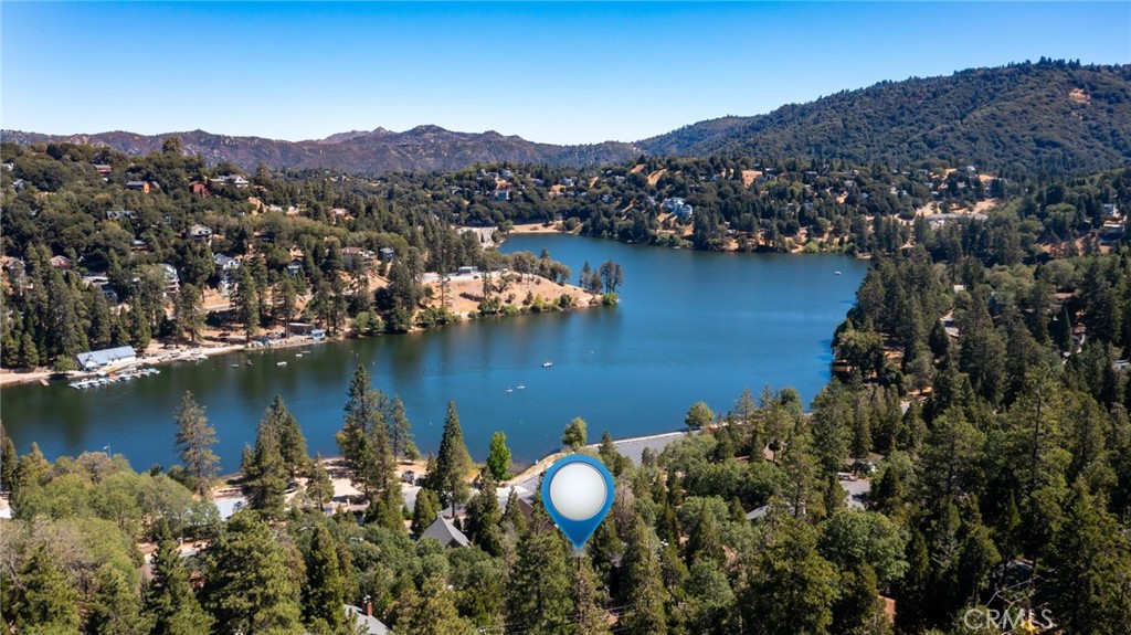 Discover your serene sanctuary at 24280 Montreaux Drive in Crestline, CA. This charming 3-bedroom, 2-bathroom home offers 1,394 square feet of inviting living space, designed to harmonize with its natural surroundings. Step inside and be greeted by the warm ambiance of the living room, featuring high beam ceilings and a cozy fireplace. The living room seamlessly leads to an expansive deck, where you can enjoy tranquil views of the lush trees, perfect for morning coffee or evening gatherings.
The entry level presents a well-appointed kitchen, one bedroom, and a full bathroom, providing convenience for everyday living. The lower level houses two additional bedrooms and a second bathroom, along with laundry and access to the back patio.
Situated on a spacious 7,800 square foot lot, this property provides ample parking for guests, enhancing its appeal despite the absence of a garage. The location is truly unbeatable, with Lake Gregory and the charming town center just a short walk away, offering a perfect balance of seclusion and accessibility.