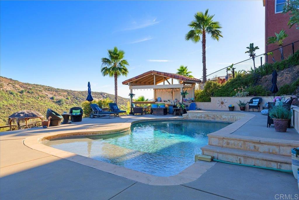 This home has the wow-factor with panoramic views and a resort-style PebbleTec pool with huge baja step in a lush, tropical setting with cabanas and horseshoe pit. Everyday feels like a vacation! Quiet cul-de-sac location.3 bedrooms + an office could be 4th bedroom. Finished space below for potential ADU. Dramatic double door entry with Grand staircase, skylights and step down living room. Formal dining room with coffered ceiling. Kitchen with granite counter and spacious family room with views and custom fireplace. Enjoy swimming, hiking, golf, tennis, pickleball and country club living in San Diego Country Estates.